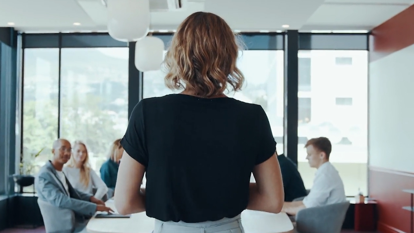 A manager addressing an audience in a conference room.