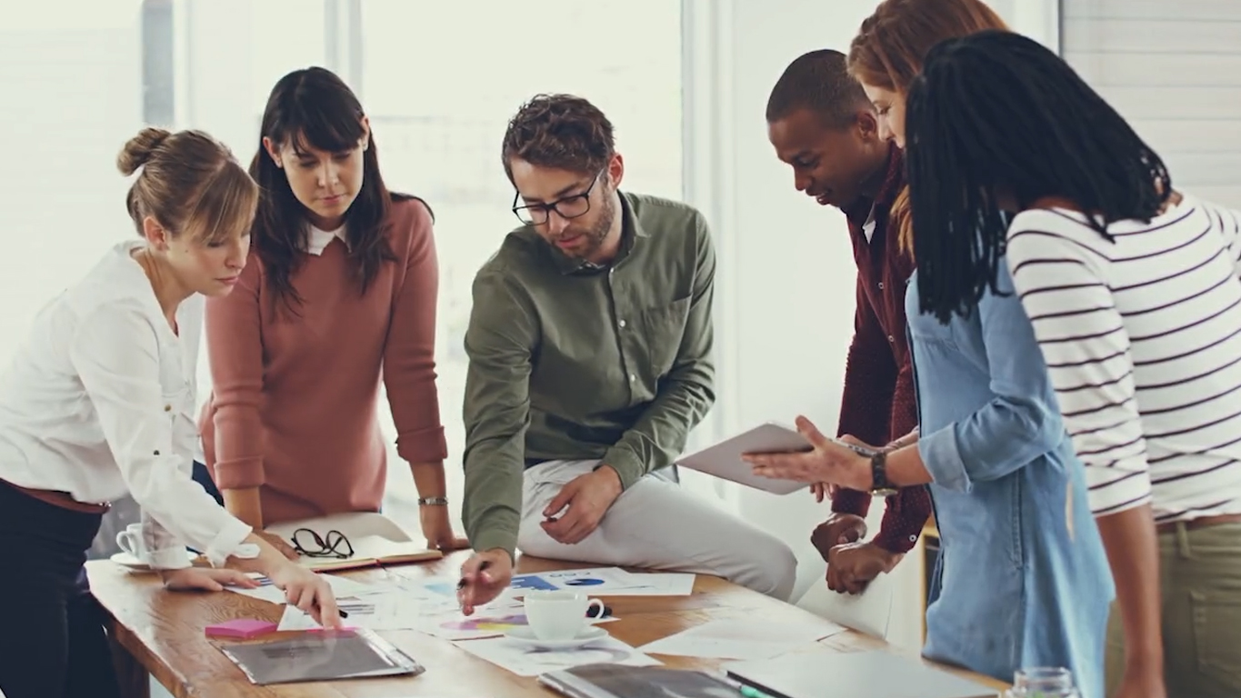 A team of professionals discussing documents and reports at a meeting.