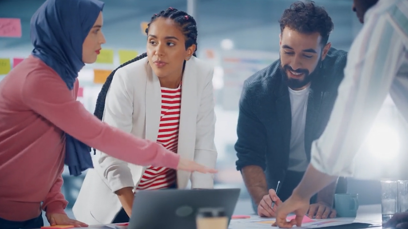 A team collaborating on a laptop in an office, exemplifying a security-first culture while working together efficiently